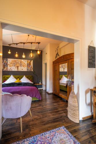 a bedroom with a bed and a chair in a room at Boutique Apartment Benz 3 in Bergisch Gladbach