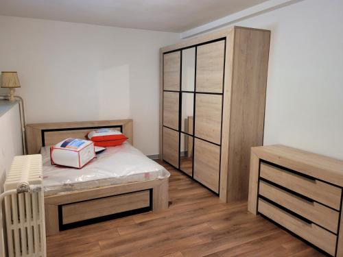 a bedroom with a bed and a wooden cabinet at 2 chambres chez l'habitant in Poitiers