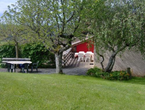 une maison avec une table et des chaises dans une cour dans l'établissement GITE les 3 COQUELICOTS, à Coublanc