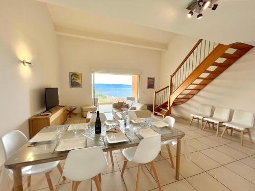 une salle à manger avec une table et des chaises et un escalier dans l'établissement Duplex Le Diana Sanguinaires AJACCIO, à Ajaccio