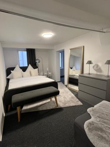a bedroom with a large bed and a mirror at Ferienwohnungen am Markt - historischer Marktplatz im Herzen der Altstadt in Eschwege