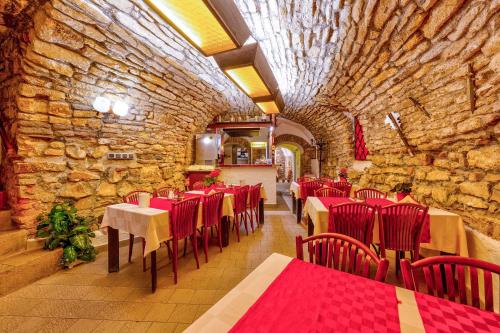 um restaurante com mesas e cadeiras vermelhas e uma parede de pedra em Betlem Club Hotel em Praga