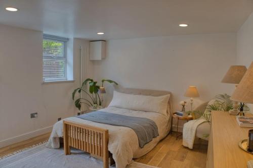 a bedroom with a bed and a table and a window at Modern self-contained Studio with own access in Stroud Green in London