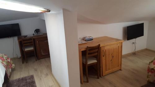 Mały pokój z biurkiem i sypialnią z łóżkiem w obiekcie Pensiunea Geostar w mieście Curtea de Argeş