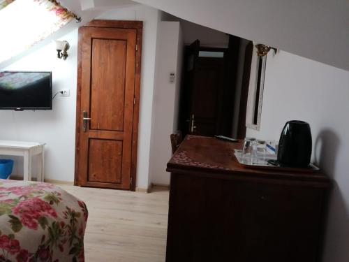 a bedroom with a dresser and a wooden door at Pensiunea Geostar in Curtea de Argeş