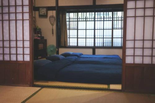 a bedroom with a large blue bed in front of a window at 台中包棟百年日式老宅 請先致電詢問日期 in Taichung