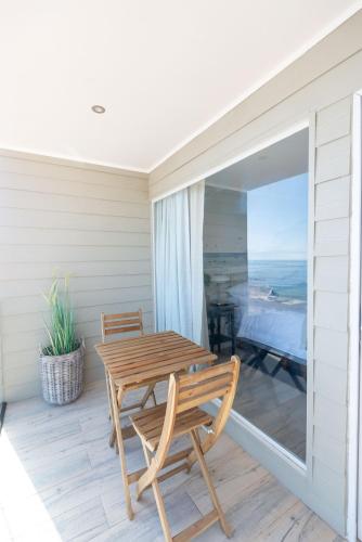a table and chairs on a porch with a view of the ocean at Nolana hotel in Taltal