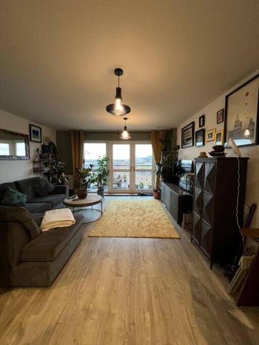 a living room with a couch and a large window at A cosy apartment near Crawley Station/Gatwick Airport in Crawley