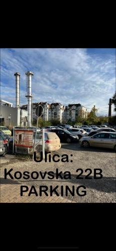 a parking lot with cars parked in front of a factory at Sobe sa sopstvenim KUPATILOM Private rooms bathroom In CENTER in Novi Sad