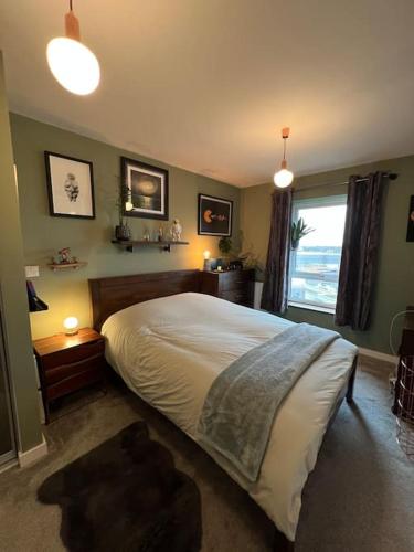 a bedroom with a large bed and a window at A cosy apartment near Crawley Station/Gatwick Airport in Crawley
