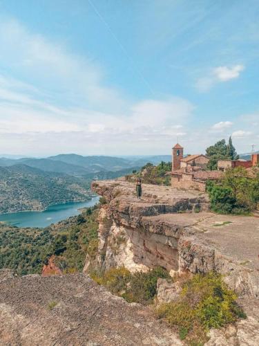 una persona parada en lo alto de un acantilado con vistas a un río en Paros, en Tarragona