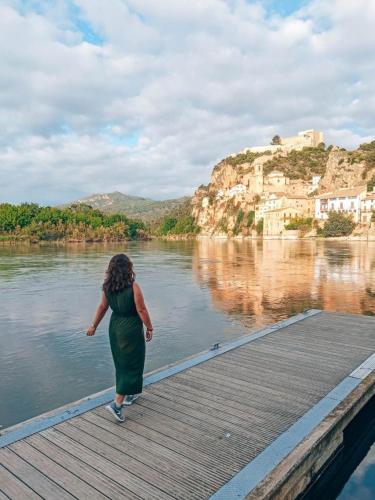 a woman walking on a wooden boardwalk over a river at Paros in Tarragona