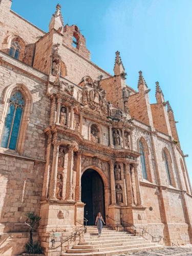 una mujer está parada frente a una iglesia en Paros en Tarragona