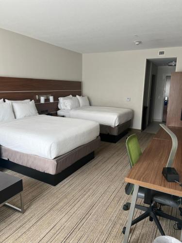 a hotel room with two beds and a desk and a chair at Holiday Inn Express & Suites Mobile - University Area by IHG in Mobile