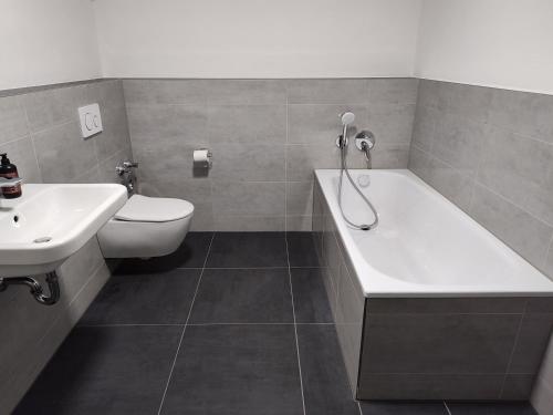 La salle de bains est pourvue d'une baignoire, de toilettes et d'un lavabo. dans l'établissement Valley of Business Frankfurt-West - Penthouse Nº1 - Three-Bedroom, à Hofheim am Taunus