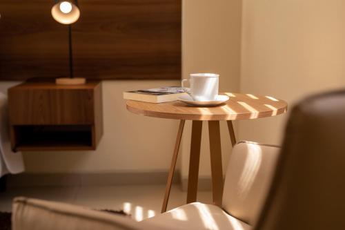 a small table with a coffee cup and a book at Equipetrol Suites apart hotel in Santa Cruz de la Sierra