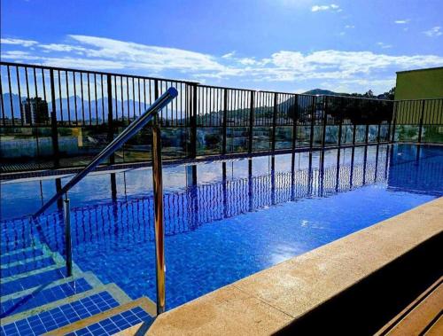 a swimming pool with blue water and a fence at Rio De Janeiro Freguesia Jacarepaguá Lotf in Rio de Janeiro