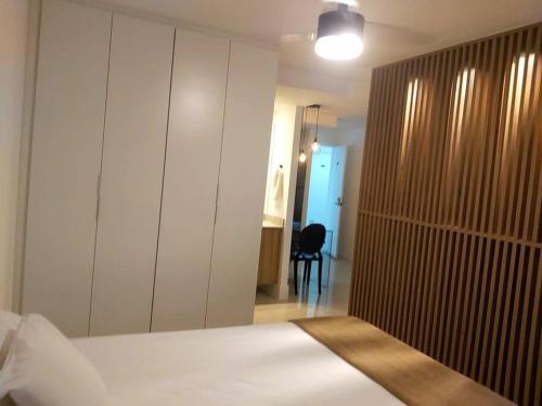 a bedroom with a bed and a closet and a chair at Rio De Janeiro Freguesia Jacarepaguá Lotf in Rio de Janeiro