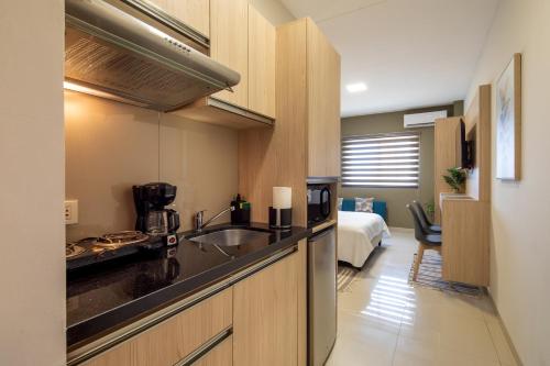 聖克魯斯的住宿－Equipetrol Suites apart hotel，一个带水槽的厨房和一张位于客房内的床