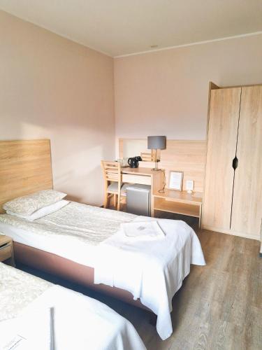 a hotel room with two beds and a desk at B & B Tomula in Gdańsk