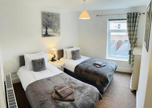 a hotel room with two beds and a window at Stylish cottage - Parking for 2 cars! in Lincolnshire