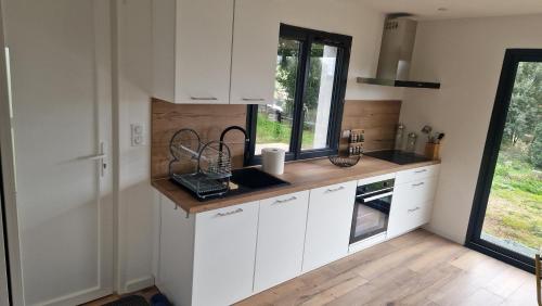 une cuisine avec des armoires blanches et une fenêtre dans l'établissement Appart A LIVIA T3 Ajaccio, à Peri