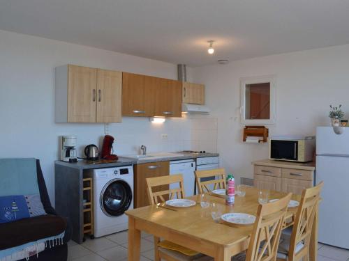 une cuisine avec une table et une cuisine avec une salle à manger dans l'établissement Maison à Saint Pierre la Mer avec Terrasse et Piscine 2 Étoiles - FR-1-229D-541, à Saint Pierre La Mer