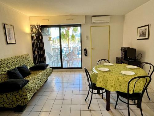 un salon avec une table et un canapé dans l'établissement Studio cabine 4 pers, parking, clim, proche plage - FR-1-225-457, à Argelès-sur-Mer