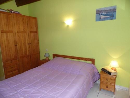 - une chambre avec un lit doté d'un couvre-lit violet dans l'établissement Charmant Studio Cabine Mezzanine avec Terrasse et Piscine à Marseillan - 6 Couchages - FR-1-326-437, à Le Castellas