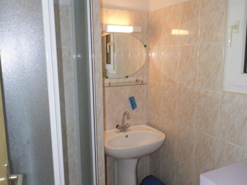 une salle de bain avec un lavabo et un miroir dans l'établissement Charmant Studio Cabine Mezzanine avec Terrasse et Piscine à Marseillan - 6 Couchages - FR-1-326-437, à Le Castellas