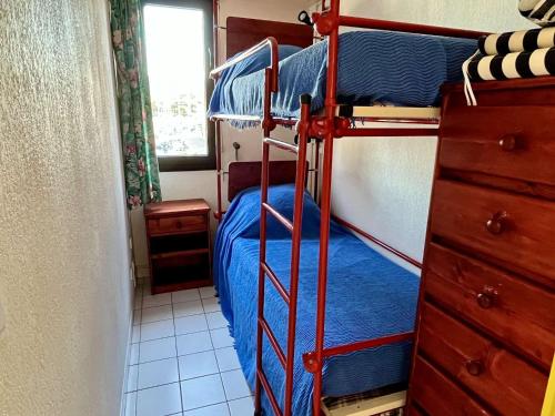 - une chambre avec 2 lits superposés et des draps bleus dans l'établissement Studio cabine 4 pers, parking, clim, proche plage - FR-1-225-457, à Argelès-sur-Mer