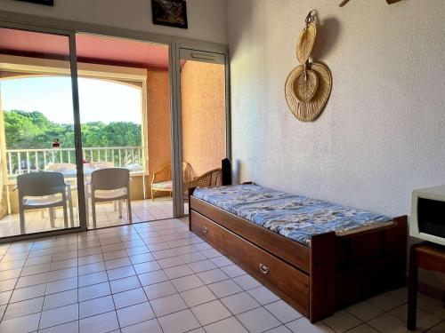 une chambre avec un lit et un balcon dans l'établissement Studio mezzanine avec piscine, proche plage et commerces - Argelès-sur-Mer - FR-1-225-639, à Argelès-sur-Mer