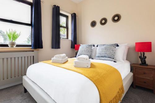 a bedroom with a large white bed with a yellow blanket at Promenade Apartments Maldon in Maldon