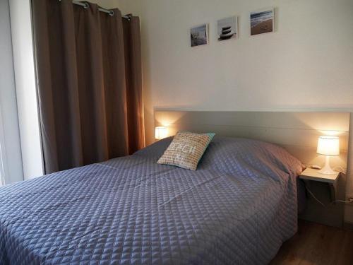 ein Schlafzimmer mit einem Bett mit einem Kissen und zwei Lampen in der Unterkunft Maison Capbreton, 3 pièces, 4 personnes - FR-1-413-126 in Capbreton