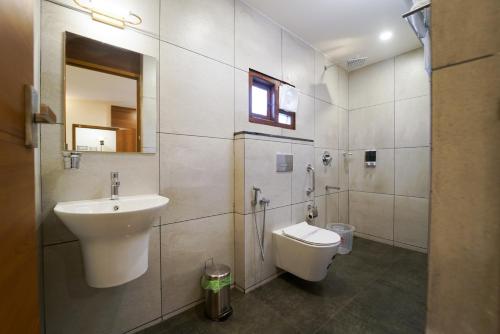 y baño con lavabo, aseo y espejo. en Grand Plaza Inn, en Kottakkal
