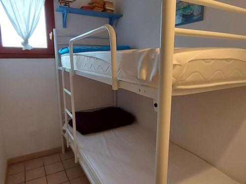 deux lits superposés dans une chambre avec fenêtre dans l'établissement Charmante maison 2 pièces cabine, terrasse, BBQ, parking privé, proche plage - Marseillan - FR-1-326-562, à Marseillan