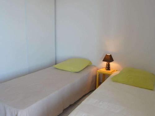 deux lits dans une chambre avec une lampe sur une table dans l'établissement Appt avec Terrasse, 2 Ch, Parking, à Saint Pierre la Mer - FR-1-229D-48, à Fleury