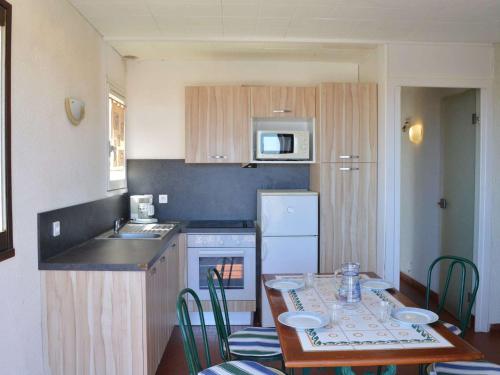 une petite cuisine avec une table et une cuisine avec une table et des chaises dans l'établissement Appartement à 50m de la plage, 2 Chambres, 1 Balcon, Quartier du Port Tranquille - FR-1-229D-77, à Fleury