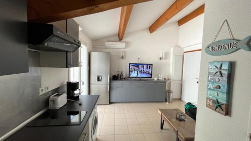 Bel appartement في سانت ماري دو لا مير: مطبخ مزود بتلفزيون ومطبخ مزود بمنضدة