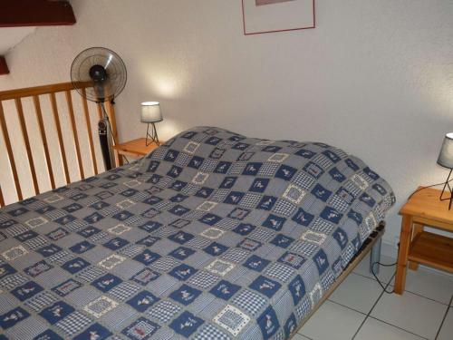 - un lit avec une couette bleue et blanche dans une chambre dans l'établissement Studio/Mezzanine Climatisé 4 Pers. à 100m Plage avec Piscine et Parking – Argelès-sur-Mer - FR-1-225-707, à Argelès-sur-Mer