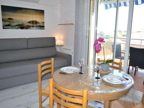 un salon avec une table et un canapé dans l'établissement Studio Cabine 4 pers, proche mer, clim, parking, animaux ok - FR-1-225-718, à Argelès-sur-Mer