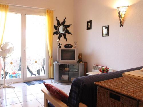 un salon avec un canapé et une télévision dans l'établissement Maison de Vacances avec Piscine et Terrasse, 800m de la Plage - 6 Couchages, Saint Pierre la Mer - FR-1-229D-82, à Fleury