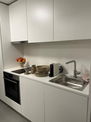 a white kitchen with a sink and a stove at Vogt Appartements in Schaanwald