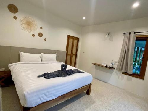sypialnia z łóżkiem ze szlafrokiem w obiekcie Sunny Cove Beach Resort Koh Phayam w mieście Ranong