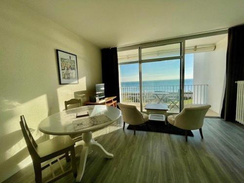 - un salon avec une table, des chaises et une grande fenêtre dans l'établissement Studio à Quiberon - 3 pers, 150m plage, parking dispo - FR-1-478-269, à Quiberon