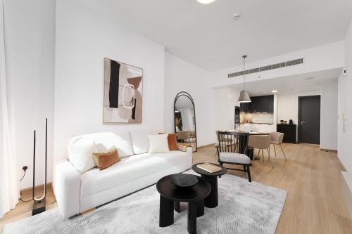 a living room with a white couch and a table at Luxe Living in our Exquisite 1 Bedroom Apartment in Dubai