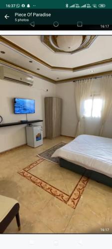 a bedroom with a bed and a flat screen tv at الينبوع الأخضر in Al Madinah