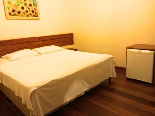 1 dormitorio con cama blanca y mesa en Quarto De Casal Econômico en Ouro Preto
