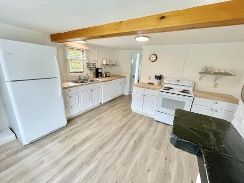 uma grande cozinha com electrodomésticos brancos e pisos em madeira em Beachfront 4 BR Spacious House! [Coastal Haven] em Tremont