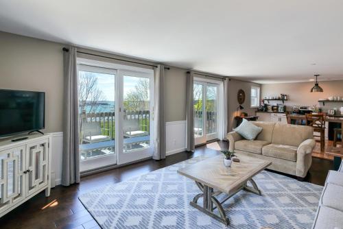 Una sala de estar con un sofá y un televisor. en 2BR Condo Downtown SWH w/ Ocean Views [Driftwood], en Southwest Harbor